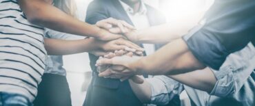 Close up view of young business people putting their hands together. Stack of hands. Unity and teamwork concept.